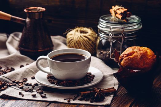 Cup of spiced coffee with homemade muffin