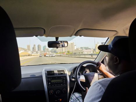 Taxi driver in Cape Town, South Africa. In the car, taxi, while driving in the back seat.