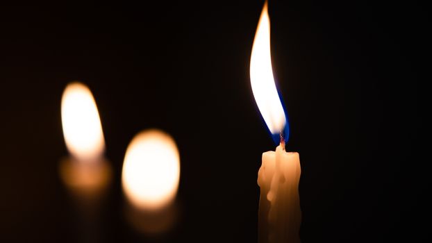 Close-up shots of yellow candles and lights on a black background with bokeh lights