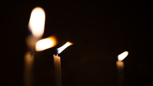 Close-up shots of yellow candles and lights on a black background with bokeh lights