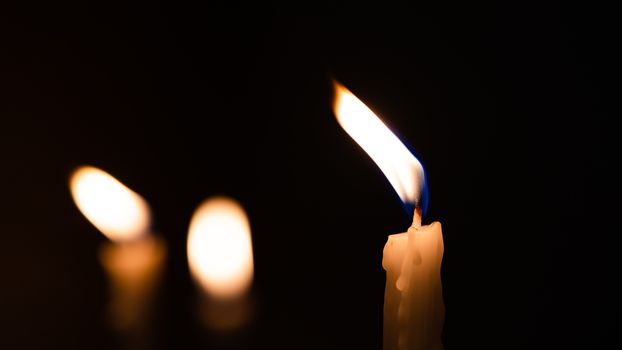 Close-up shots of yellow candles and lights on a black background with bokeh lights