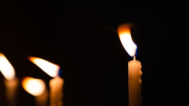 Close-up shots of yellow candles and lights on a black background with bokeh lights