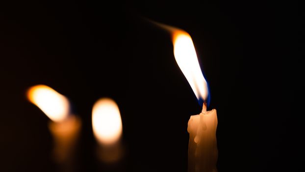 Close-up shots of yellow candles and lights on a black background with bokeh lights