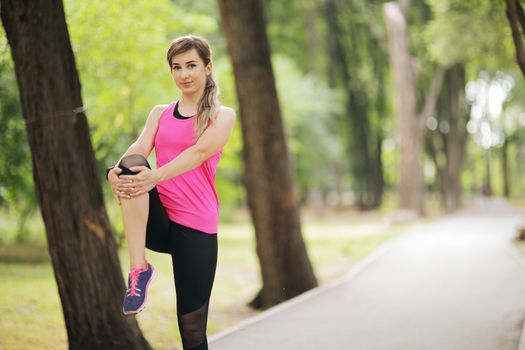 The young woman is engaged in sports fitness in nature forest Healthy fit living. Motivation healthy fit living. Running shoe. Beautiful sunlight. Woman warming up before running