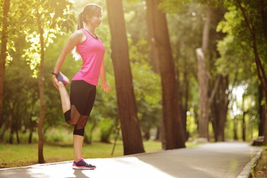 The young woman is engaged in sports fitness in nature forest Healthy fit living. Motivation healthy fit living. Running shoe. Beautiful sunlight. Woman warming up before running