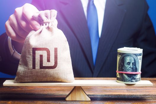 A man puts Israeli shekel money bag on the scales opposite to the dollar. Investments in foreign currency bonds. Protecting savings from inflation. Exchange rate, comparison of economic indicators.