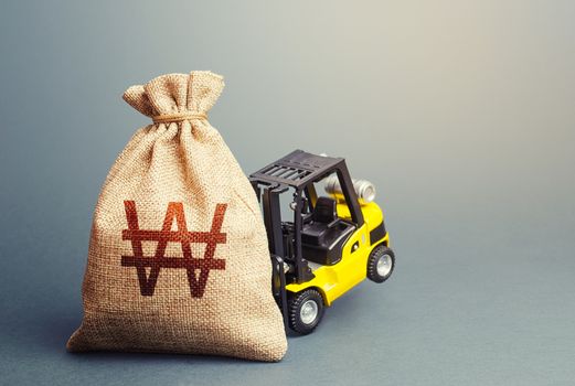 Yellow forklift unable to lift a south korean won money bag. Interest rate. Stimulating economy. Helicopter money, subsidies soft loans. Strongest financial assistance, support of business and people.