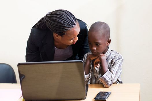 Smiling young woman learns computer skills from child with kindness.