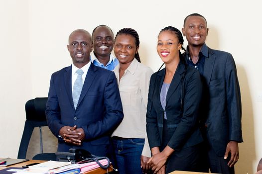 Group of happy business people posing together at the service watching the camera