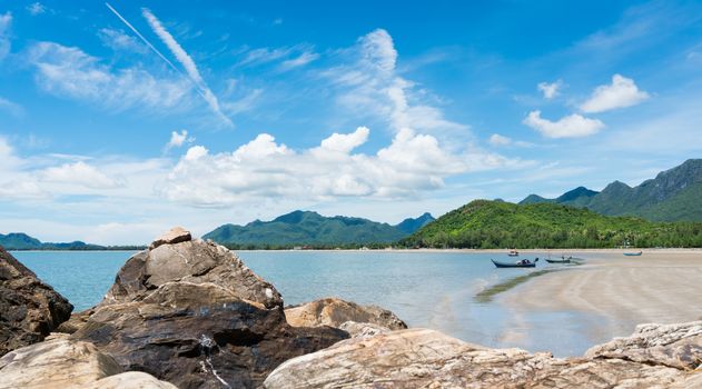 Fishing Boat on beach and green tree mountain and blue sky and sea and rock or stone at Prachuap Khiri Khan Thailand. Summer concept in 
relaxation mood for design