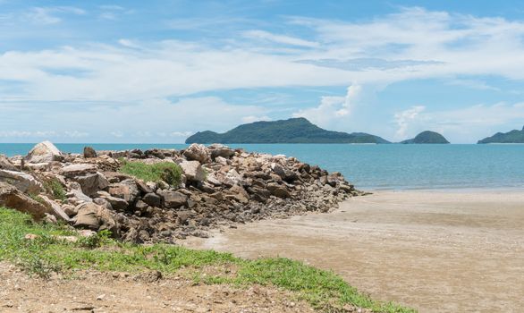 Rock or stone mound or pile on the beach at Prachuap Khiri Khan Thailand. Beach and sea or brine and blue sky and green tree mountain or hill. 
Summer concept in relaxation mood for design