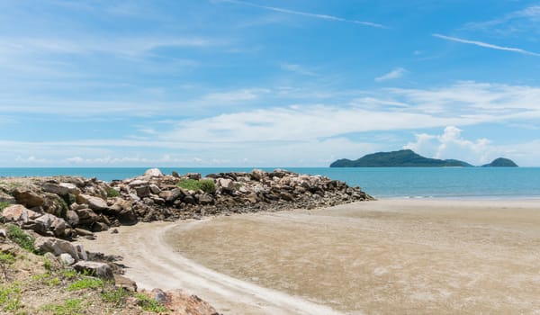 Rock or stone mound or pile on the beach at Prachuap Khiri Khan Thailand. Beach and sea or brine and blue sky and green tree mountain or hill. 
Summer concept in relaxation mood for design