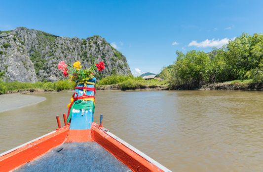 Khao Dang canal boat trip at Prachuap Khiri Khan Thailand. Boat or fishing boat and rock or stone mountain or hill with blue sky and cloud and 
green tree and water. Landscape or scenery summer concept for boat trip