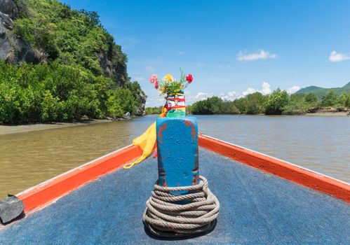 Khao Dang canal boat trip at Prachuap Khiri Khan Thailand. Boat or fishing boat and rock or stone mountain or hill with blue sky and cloud and green tree and water. Landscape or scenery summer concept for boat trip