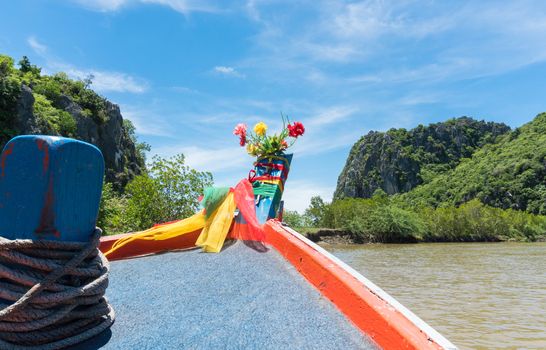 Khao Dang canal boat trip at Prachuap Khiri Khan Thailand. Boat or fishing boat and rock or stone mountain or hill with blue sky and cloud and green tree and water. Landscape or scenery summer concept for boat trip