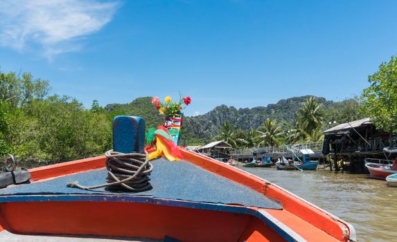 Fishing village and fishing boat at Khao Dang village. Old home and fishing boat and blue sky and cloud and water and green tree. Landscape or scenery summer concept for boat trip