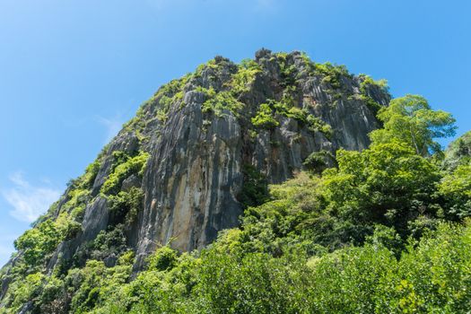 Stone or rock mountain or hill with green tree and blue sky and water and cloud at Khao Dang canal Prachuap Khiri Khan Thailand. Landscape or 
scenery summer concept for boat trip