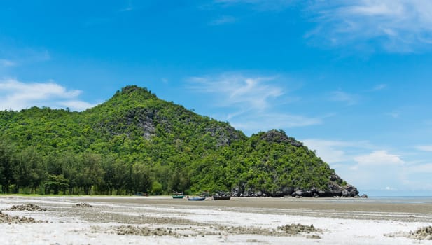 Rock or stone mountain or hill and blue sky and fishing boat at Sam Phraya beach Prachuap Khiri Khan Thailand. Landscape or scenery in 
natural for summer concept