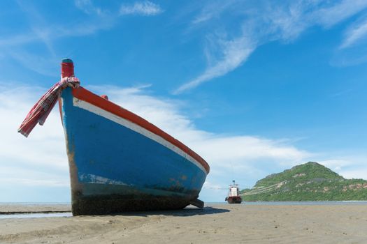 Blue fishing boat or fisherman boat or ship on Sam Roi Yod bech Prachuap Khiri Khan Thailand with blue sky and cloud and blue sea and 
mountain or hill. Landscape or scenery for summer season concept