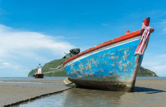 Blue fishing boat or fisherman boat or ship on Sam Roi Yod bech Prachuap Khiri Khan Thailand with blue sky and cloud and blue sea and 
mountain or hill. Landscape or scenery for summer season concept