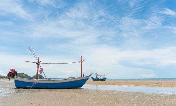 Blue fishing boat or fisherman boat or ship on Sam Roi Yod bech Prachuap Khiri Khan Thailand with blue sky and cloud and blue sea and 
mountain or hill. Landscape or scenery for summer season concept