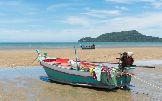 Green fishing boat or fisherman boat or ship on Sam Roi Yod bech Prachuap Khiri Khan Thailand with blue sky and cloud and blue sea and 
mountain or hill. Landscape or scenery for summer season concept