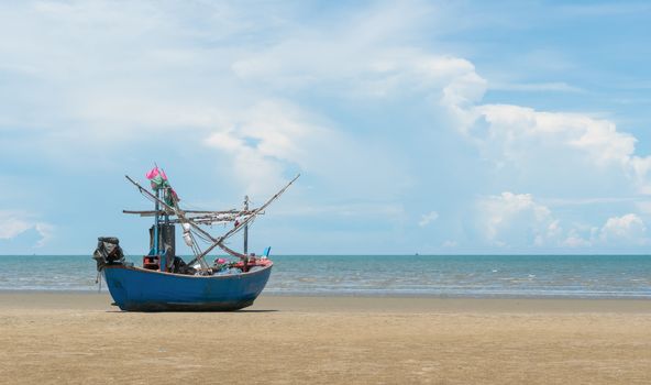 Blue fishing boat or fisherman boat or ship on Sam Roi Yod bech Prachuap Khiri Khan Thailand with blue sky and cloud and blue sea. Landscape or scenery for summer season concept