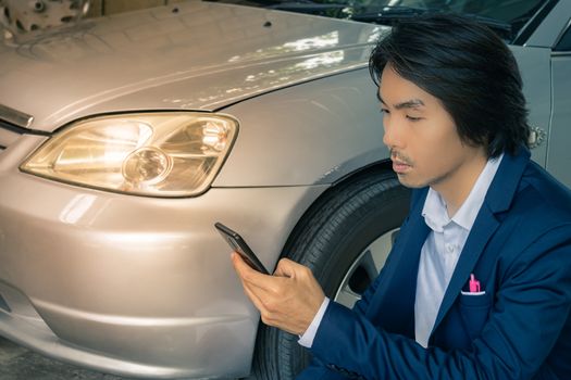 Asian Insurance Agent or Insurance Agency in Suit Touch Smartphone and Inspecting Car Crash from Accident for Claim at Outdoor Place in Vintage Tone