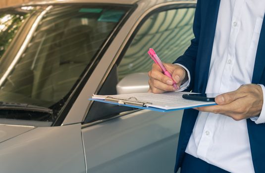 Standing Asian Insurance Agent or Insurance Agency in Suit Checking Car Crash Data Report from Accident for Claim at Outdoor Place in Vintage Tone