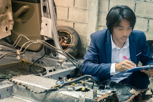 Asian Insurance Agent or Insurance Agency in Suit Inspecting Car Crash from Accident and Write Report for insurance Claim at Outdoor Place in Vintage Tone