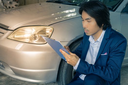 Asian Insurance Agent or Insurance Agency in Suit Reading Report and Inspecting Car Crash from Accident for Claim at Outdoor Place in Vintage Tone