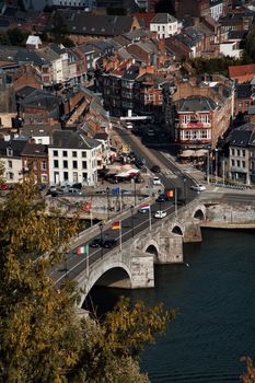 Top view of the old town and ancient bridge on the river in Belgium, Namur. Cars drive past the flags of European countries