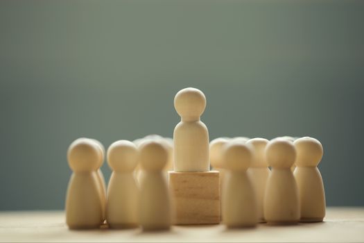 Successful business team leader concept: Businessman standing at the highest point on wooden block stand out from the crowd. depicts of career growth up or business success.