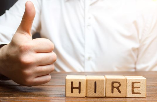 Businessman shows thumb up and hiring inscription. Consent to hire an employee, good recommendations. Recruitment concept. Search for employees and professionals on favorable terms.