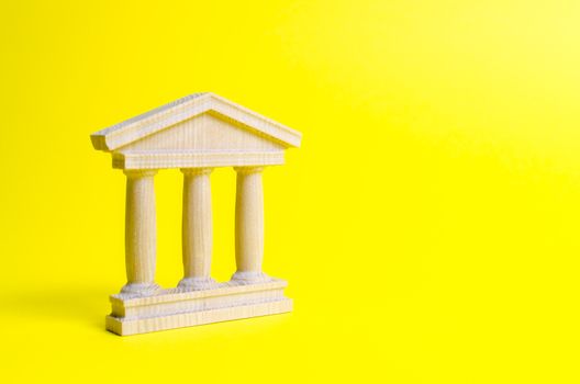 wooden government building on a yellow background. The authorities, the sovereignty of the country and the rule of law. concept of state administration and economic institutions. Bank or university