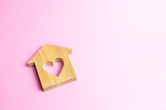 House with a heart on a pink background. The concept of finding a rental house or apartment for a romantic pastime. Valentine's Day. Affordable housing for couples lovers. Shared housing, new life.