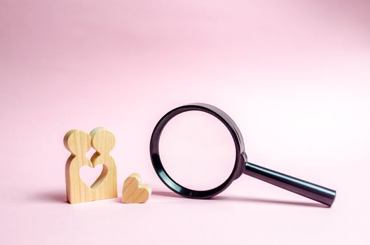 A young Couple of lovers of lovers are standing near to a magnifying glass. concept of finding a couple on Valentine's Day. Declaration of love and the creation of strong love relationships. Dating