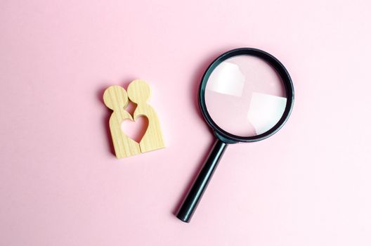 A young pair of lovers and a magnifying glass. The concept of finding a couple on Valentine's Day. Declaration of love and the creation of strong love relationships. Dating and flirt, search for love