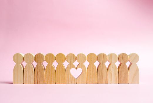 Two figures of people in a row form a void in the shape of a heart. Concept of love and search for the second half. Find a soul mate and start a family. Love and romance, real secret feelings