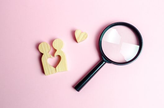 A young pair of lovers and a magnifying glass. Search for love and creation of strong love relationships. Dating and flirt, search for a love partner. concept of finding a couple on Valentine's Day.