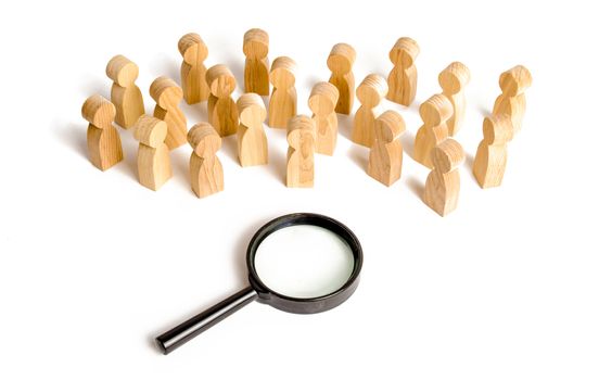 Huge crowd of people stand near a magnifying glass on a white background. Search for work. Human resources, management. concept of the search for people and workers. Sociology and psychology
