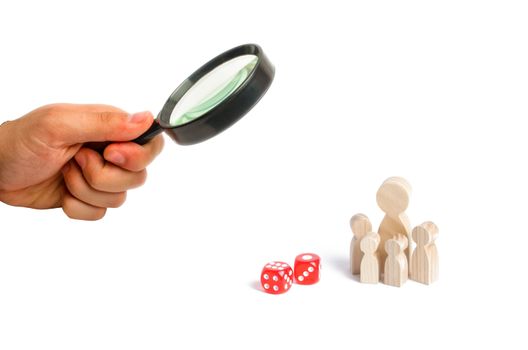Magnifying glass is looking at the Magnifying glass is looking at the eople are standing near dice. The family stands near the dice cubes. The concept of gambling, the dependence on gambling.
