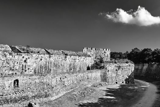 The moat and turrets of the medieval castle of the Joannite Order in the city of Rhodes, black and white