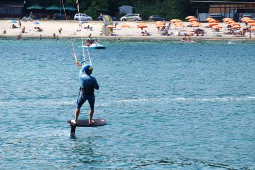 Varna, Bulgaria - July, 19, 2020: a man is kiting the sea against the background of the beachVarna