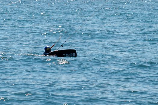 Varna, Bulgaria - July, 19, 2020: a man trying to climb on a kiteboard