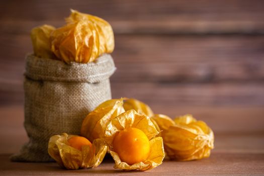 Cape gooseberry in burlap bags. Concept of health care or herb. Closeup and copy space for text.