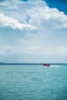 red speed boat driving on ocean for sent passenger to pier