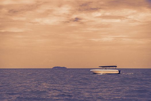 speed boat driving on purple ocean with orange sky