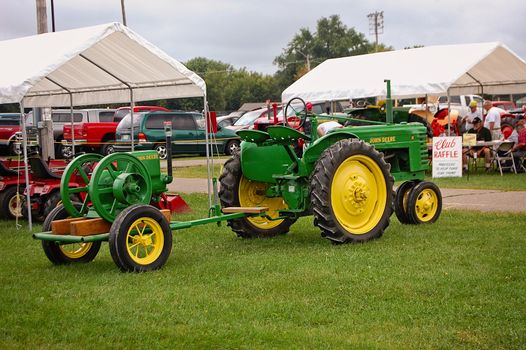 This is a vintage farm tractor with a vintage engine at county fair.