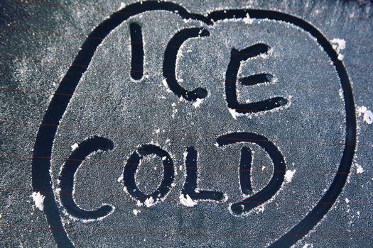 Frozen car window with a frost ice cold message text sign in the winter stock photo